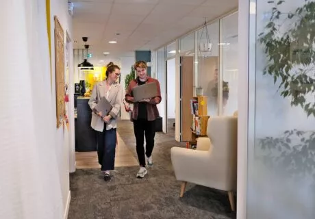 Christina et Arnaud marchent dans l'Agence en regradant l'écran d'un ordinateur